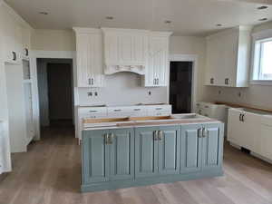 Kitchen featuring gray cabinetry, white cabinets, and a kitchen island