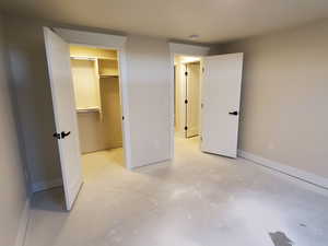 Unfurnished bedroom with a walk in closet and a closet