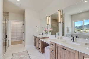 Bathroom with a mountain view, vanity, a shower with shower door, and tile patterned flooring