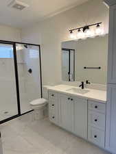 Bathroom with vanity, toilet, and an enclosed shower