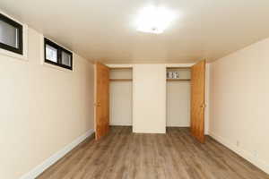 Unfurnished bedroom featuring two closets and hardwood / wood-style flooring