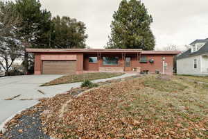 Ranch-style house featuring a front yard and a garage