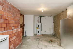 Interior space featuring electric water heater and laundry hook ups