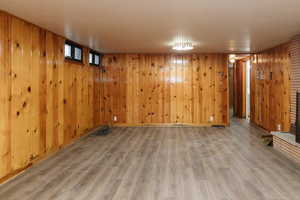 Basement with wood-type flooring and wooden walls