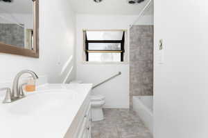 Full bathroom with tile patterned floors, vanity,  shower combination, and toilet