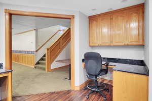 Office area featuring wood-type flooring and built in desk