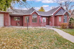 Single story home featuring a front yard and a garage