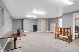 Interior space with light carpet and a textured ceiling