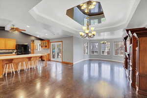 Living room featuring a raised ceiling, dark hardwood / wood-style flooring, and crown molding