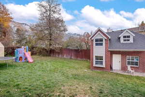 View of yard with a playground, a mountain view, and a trampoline