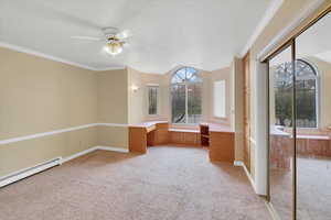 Interior space with ceiling fan, crown molding, light carpet, and a closet