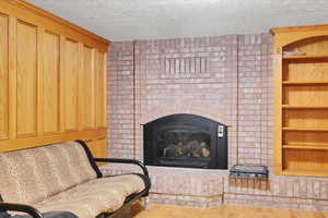 Living room with a textured ceiling and hardwood / wood-style flooring