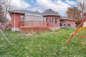 Rear view of house with a yard, a patio area, and a wooden deck