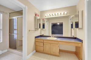 Bathroom with tile patterned flooring, vanity, and a shower with shower door