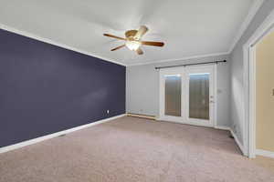 Carpeted spare room with ceiling fan, ornamental molding, and a baseboard radiator