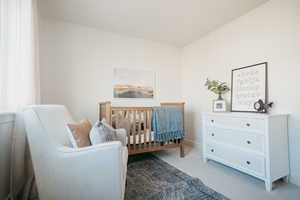 Bedroom with carpet and a crib