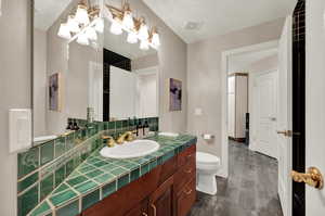 Bathroom with tasteful backsplash, vanity, and toilet