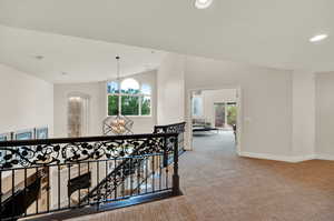 Hall featuring a chandelier and carpet floors