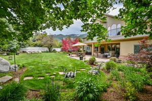 View of yard with an outdoor living space, a mountain view, and a patio