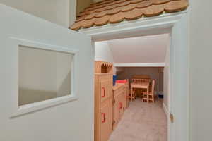 Interior space featuring light colored carpet and vaulted ceiling