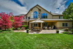 Back of house with an outdoor living space, a yard, and a patio