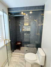 Bathroom with a shower with shower door and toilet