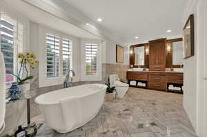 Bathroom featuring crown molding, toilet, a bathtub, vanity, and tile walls