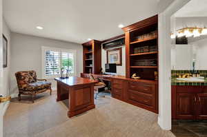 Carpeted office with built in desk and sink