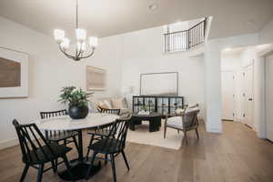 Dining room with wood-type flooring and an inviting chandelier