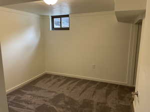 Spare room with dark carpet and a textured ceiling