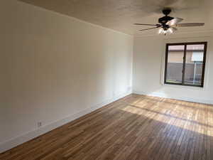 Spare room with a textured ceiling, hardwood / wood-style flooring, and ceiling fan