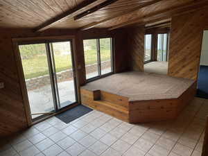 Interior space featuring access to exterior, multiple windows, and wooden walls