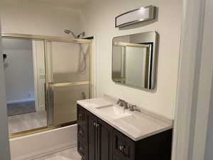 Bathroom with vanity and enclosed tub / shower combo