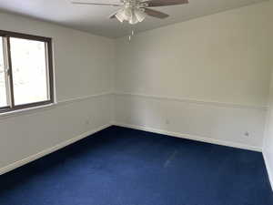 Carpeted spare room with ceiling fan