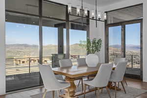 Dining space with a mountain view, hardwood / wood-style floors, and a wall of windows