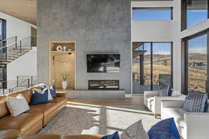 Living room featuring a fireplace, a high ceiling, and hardwood / wood-style flooring