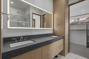 Bathroom with tiled shower and vanity