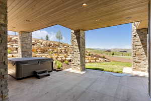 View of patio featuring a mountain view and a hot tub