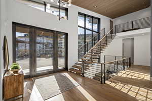 Entryway featuring wooden ceiling, a high ceiling, and hardwood / wood-style flooring