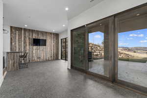 Unfurnished living room featuring wooden walls