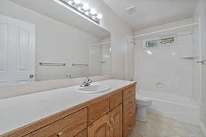 Full bathroom featuring bathtub / shower combination, vanity, and toilet