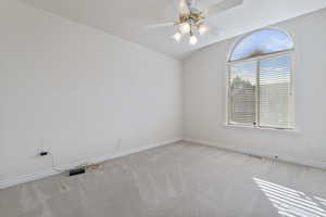 Unfurnished room featuring ceiling fan and light carpet