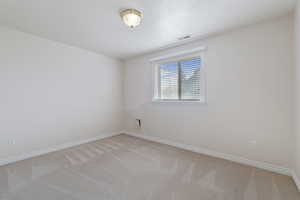 Empty room featuring light colored carpet