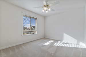 Carpeted empty room with ceiling fan