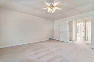 Carpeted empty room featuring ceiling fan