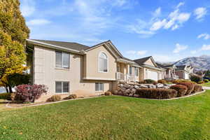 View of front of home featuring a mountain view, a garage, and a front lawn