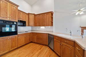 Kitchen featuring kitchen peninsula, sink, black appliances, and light hardwood / wood-style flooring