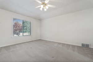 Carpeted empty room with ceiling fan