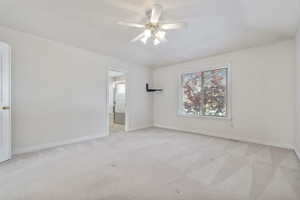 Carpeted spare room with ceiling fan