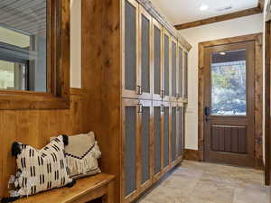 Mudroom with wood walls and crown molding